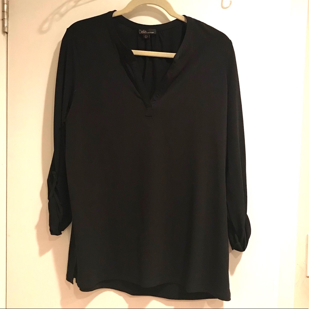 Black v-neck blouse with rolled up sleeves.